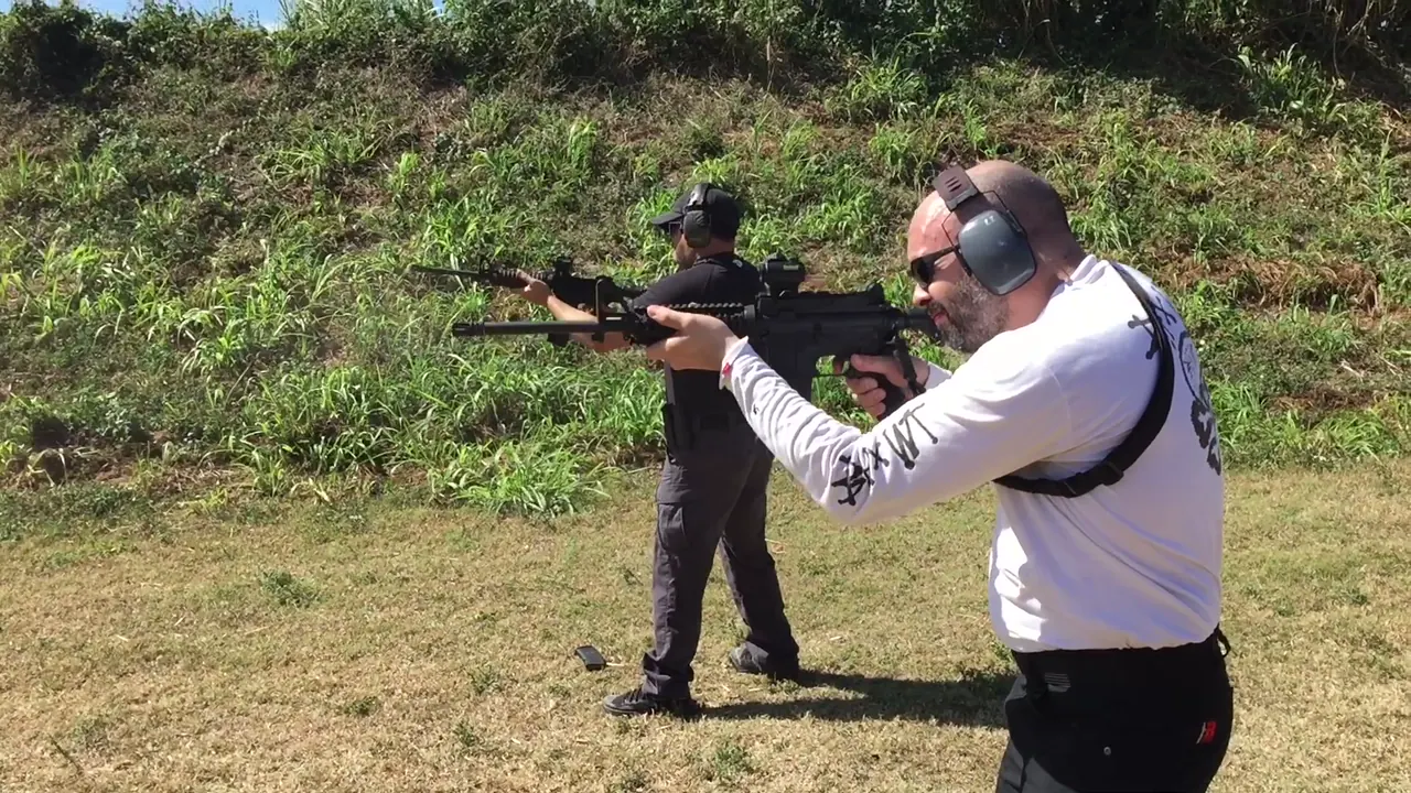 Two students firing carbines on the line during a reload drill in advanced rifle training