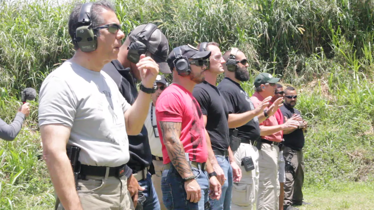 Armed security team standing in line on the range with holstered pistols and ear protection