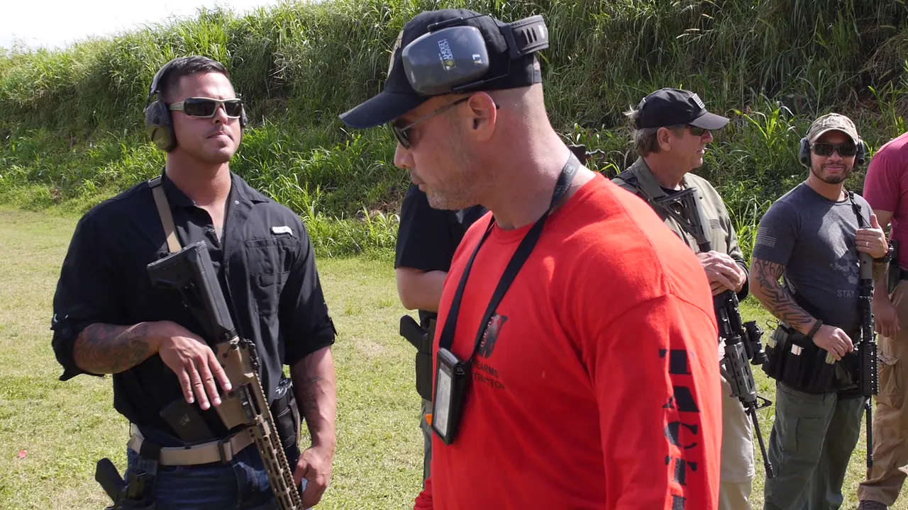 Instructor talking with armed team members holding carbines during team training