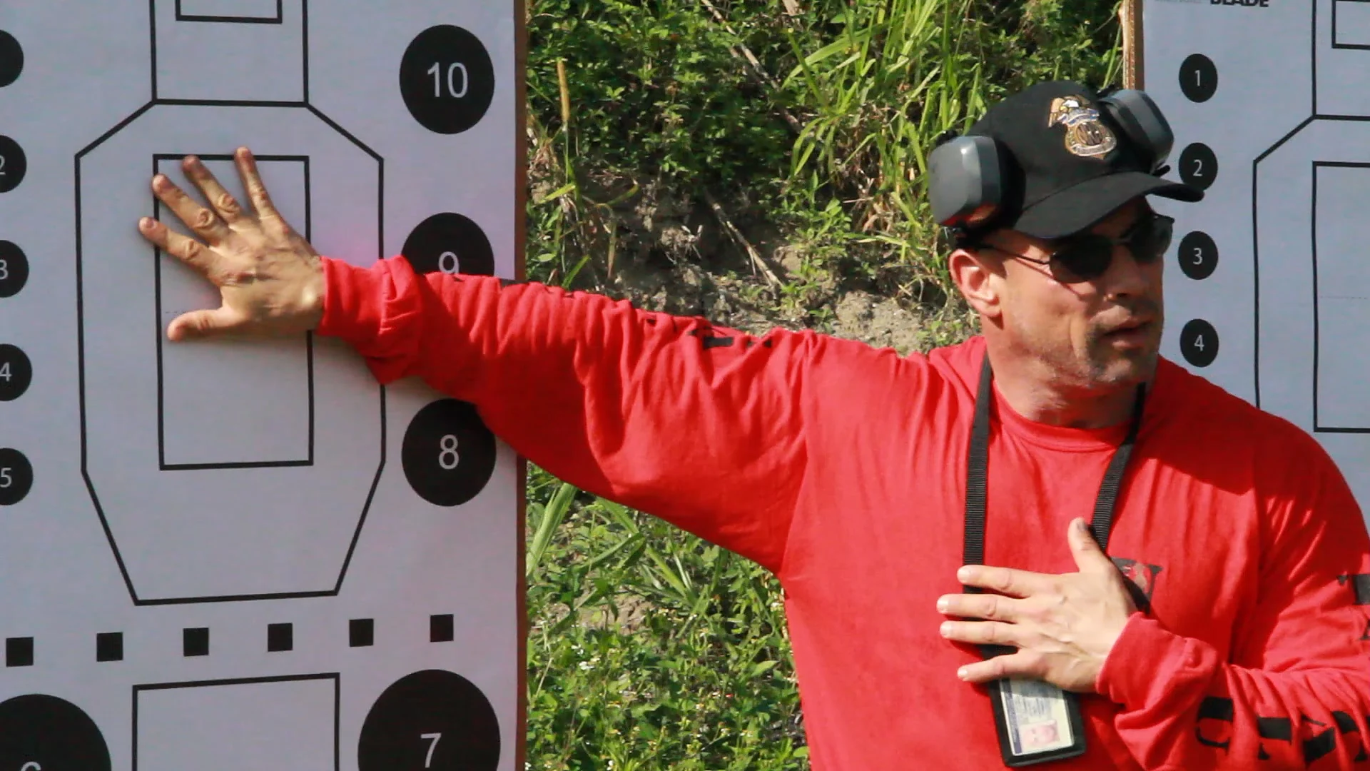 Stephen L. Cohen in a Tactical U shirt explaining shot placement on a training target