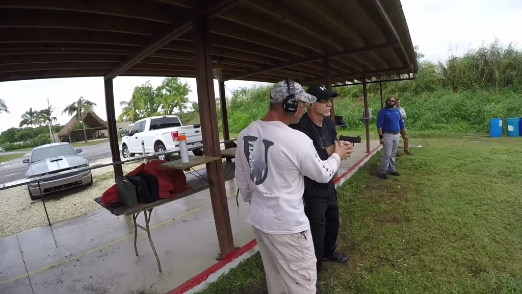 Tactical U instructor providing individual feedback during outdoor handgun training