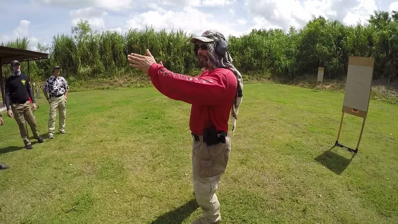 Instructor in a red shirt demonstrating a drill on the range