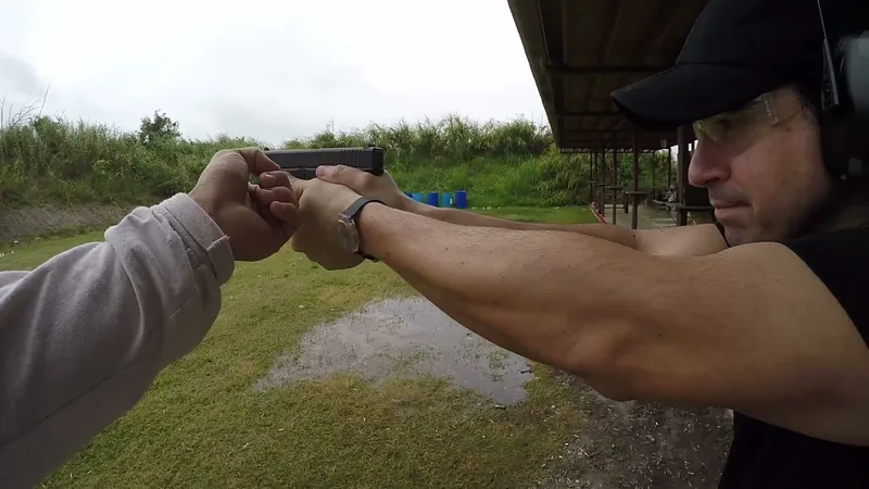 Close view of a pistol held at arm length during a malfunction drill