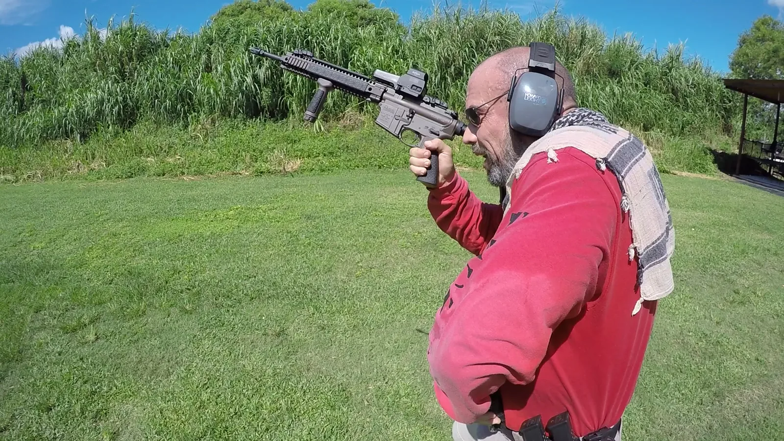 Tactical U instructor with a rifle reaching for a fresh magazine during reload training