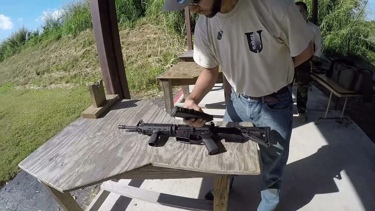 Student performing a one-hand rifle magazine change at the bench