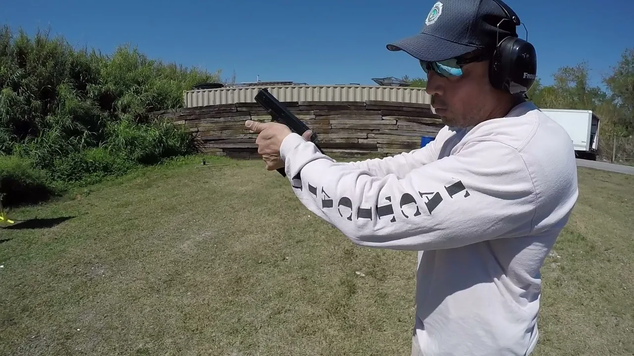 Tactical U instructor aiming a pistol on an outdoor South Florida range during CCW certification training