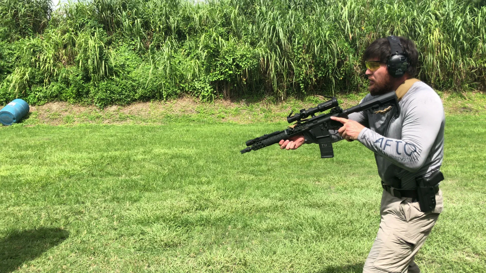 Tactical U student with a rifle at the ready on an outdoor range