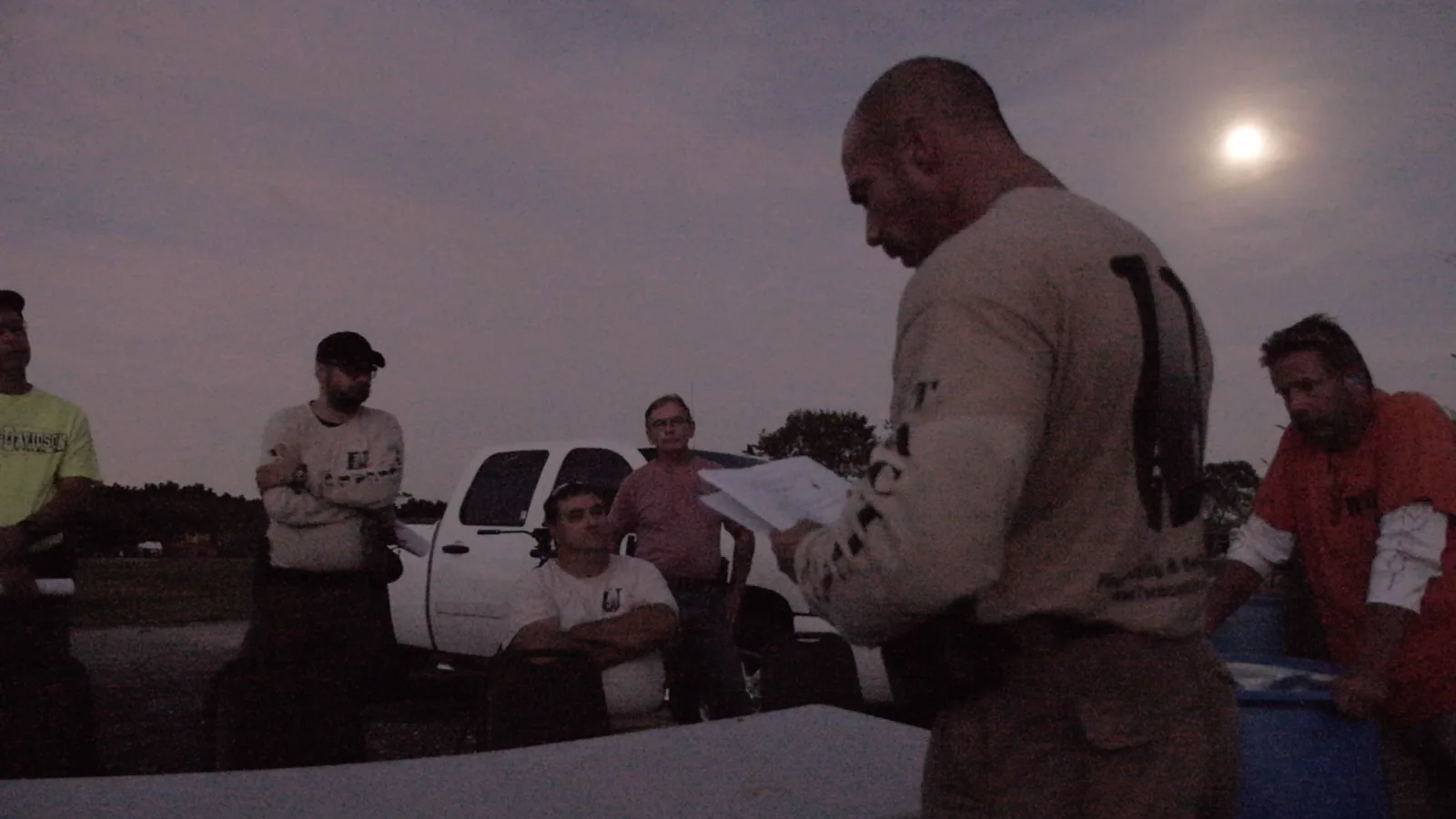 Stephen L. Cohen giving the safety briefing at dusk before a Tactical U night fire class, moon rising behind him