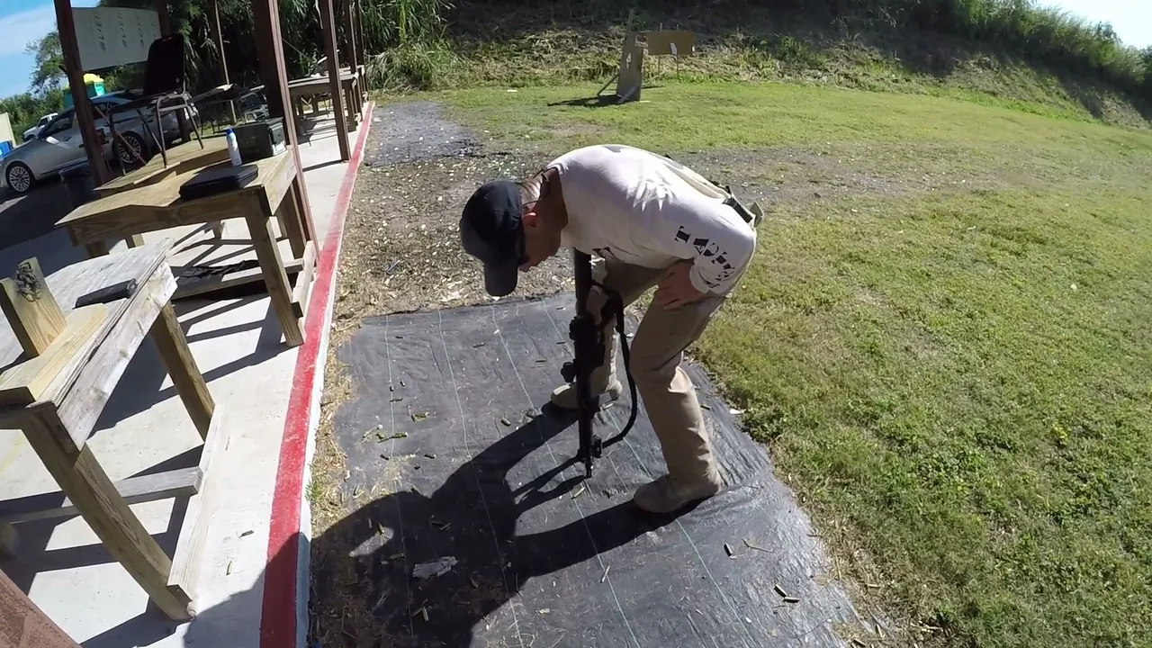 Shooter clearing an AR malfunction one-handed by bracing the rifle against the leg