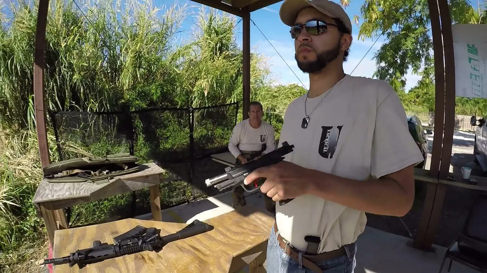 Student working a pistol malfunction drill at the covered bench during malfunction clearance training