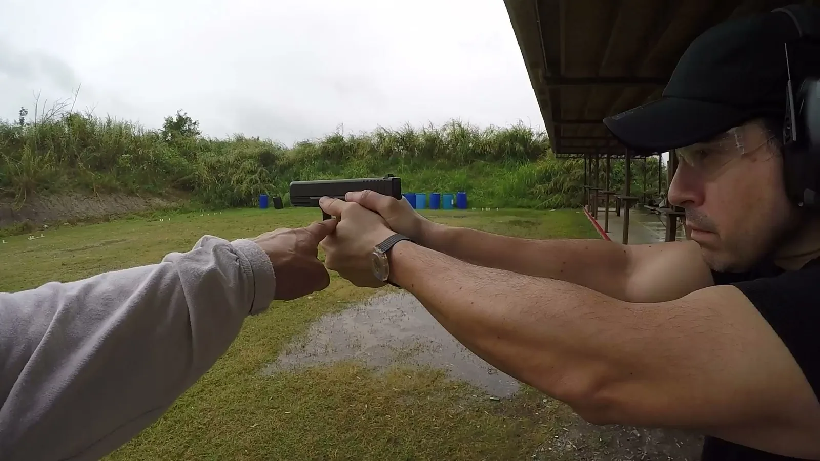 Tactical U instructor correcting a student’s two-handed pistol grip during private handgun training