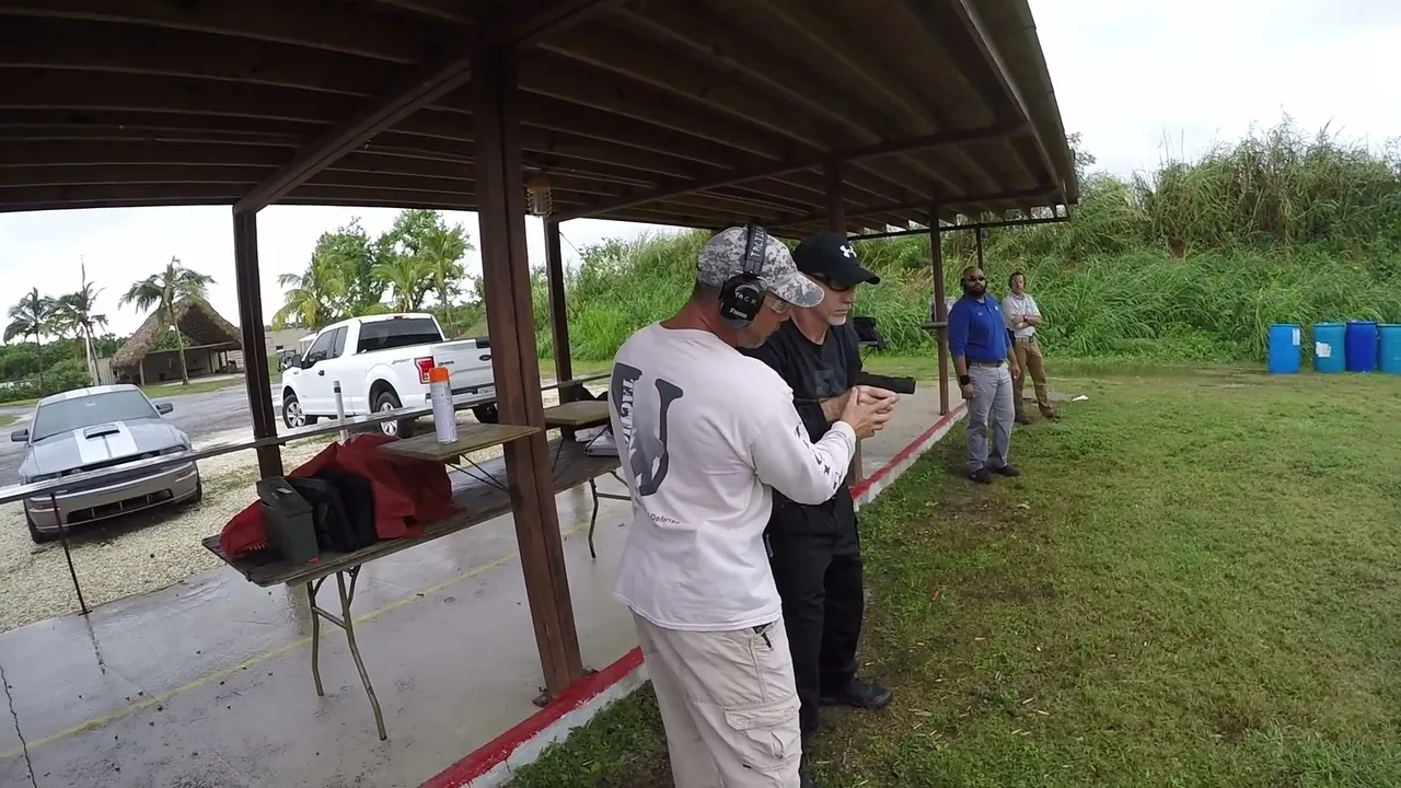 Tactical U instructor coaching a pistol student at the firing line