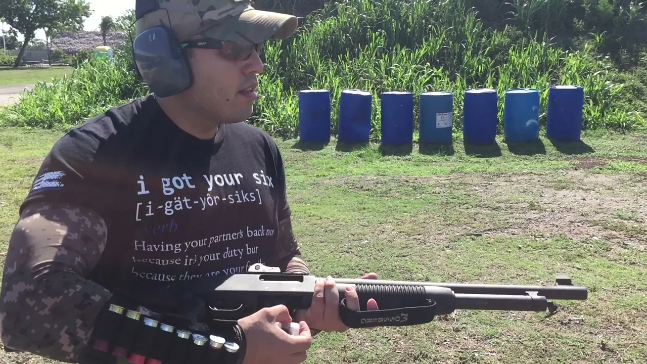 Student with eye and ear protection loading a pump shotgun on an outdoor range