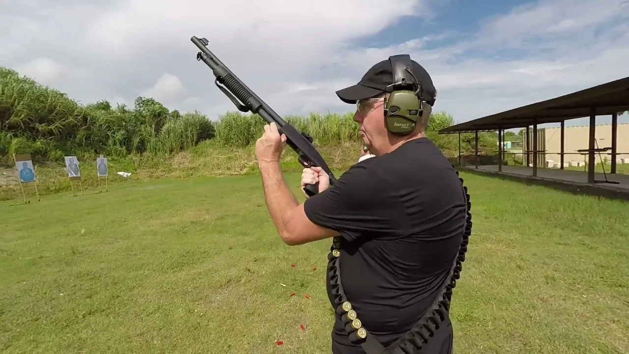 Student with ear protection handling a raised pump shotgun on an outdoor range during private shotgun training