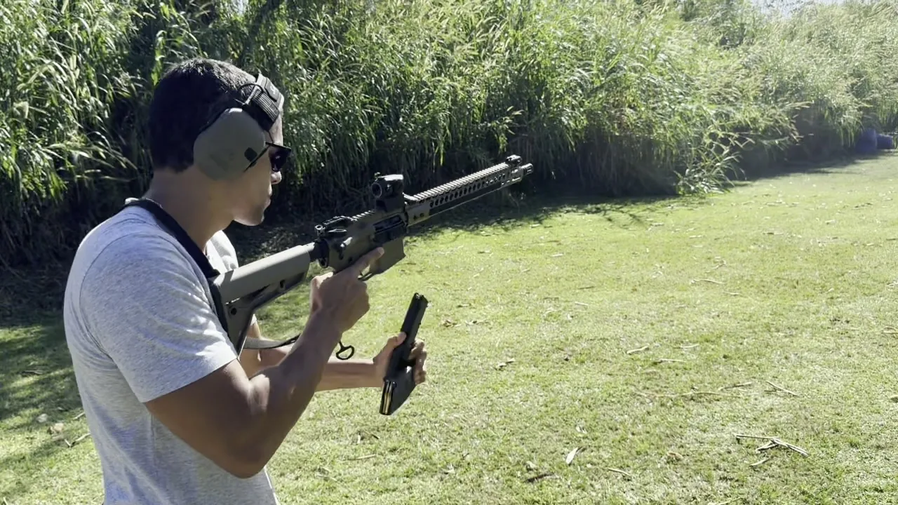 Student holding a fresh magazine during a rifle reload drill on an outdoor range