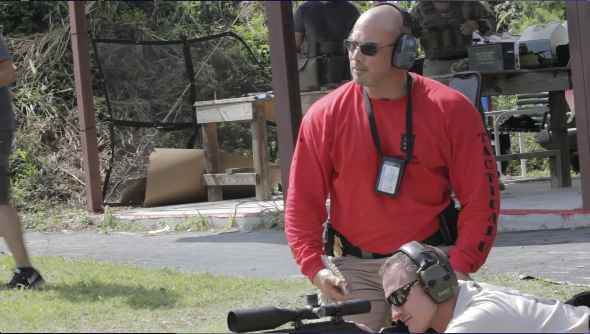 Stephen L. Cohen coaching a student behind a scoped rifle during Tactical U outdoor training