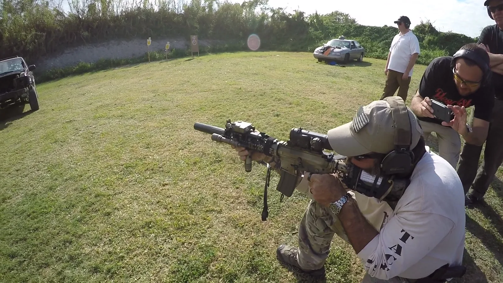 Tactical U instructor kneeling with an AR-style rifle on an outdoor range during tactical rifle fundamentals