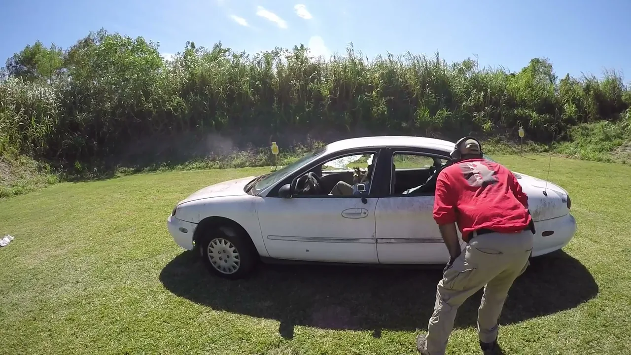 Tactical U instructor supervising a student working around a white car during a Vehicle Tactics Level One drill